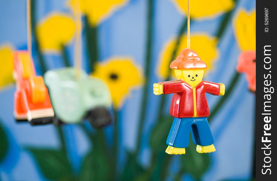Plastic figurine of a man on a mobile against a colorful painted background. Plastic figurine of a man on a mobile against a colorful painted background