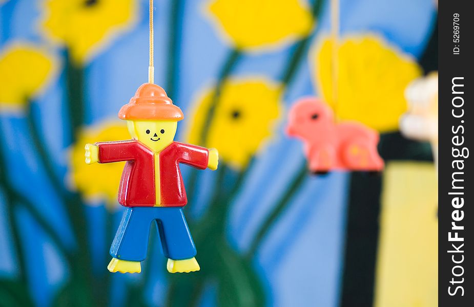 Plastic figurine of a man on a mobile against a colorful painted background. Plastic figurine of a man on a mobile against a colorful painted background