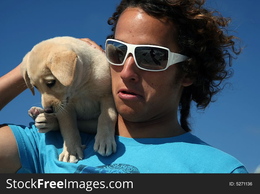 Young man holding his labrador puppy. Young man holding his labrador puppy