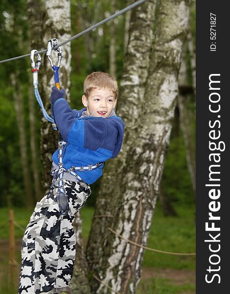 Young boy climbing  in the forest