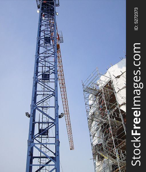 Overview of building site as construction taking place with crane.