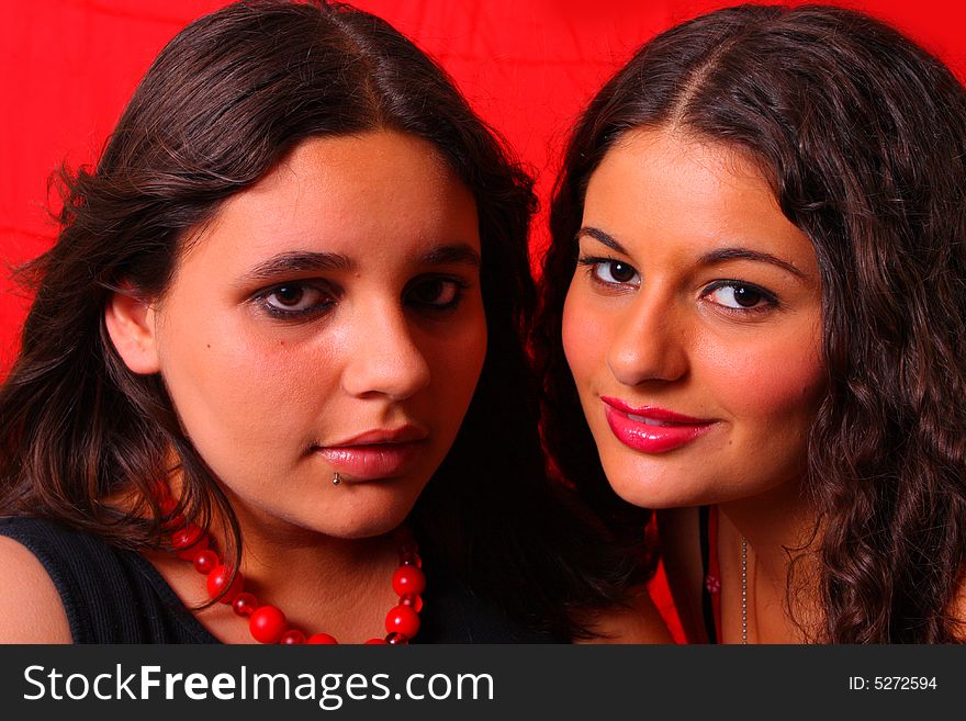 Two young teens on a red background.