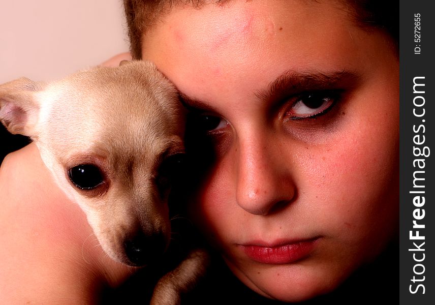 Teenage boy holding his chihuahua near his head. Teenage boy holding his chihuahua near his head.