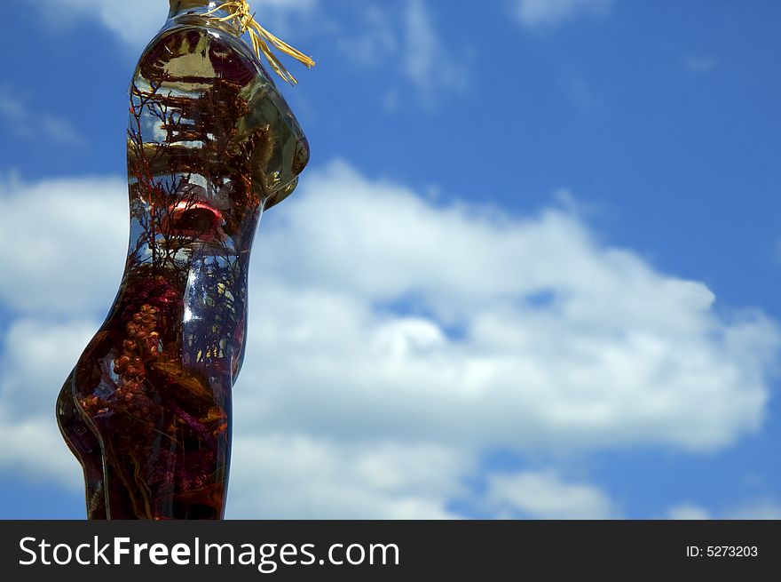 Glass woman with flowers on a background of sky. Glass woman with flowers on a background of sky