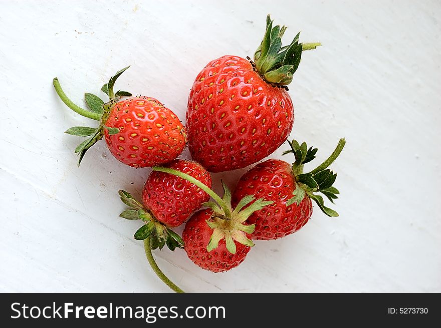 Set of fresh strawberries on white painted board