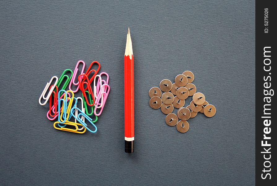 Composition from a pencil, a knife, buttons and multi-coloured paper clips. Composition from a pencil, a knife, buttons and multi-coloured paper clips.