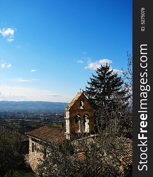 A view of an old church bell tower and the Umbrian countryside in Assisi, Italy. A view of an old church bell tower and the Umbrian countryside in Assisi, Italy.