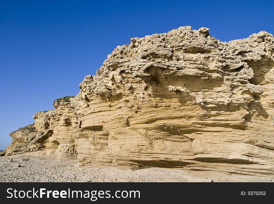 Coarse sand cliff near the sea.