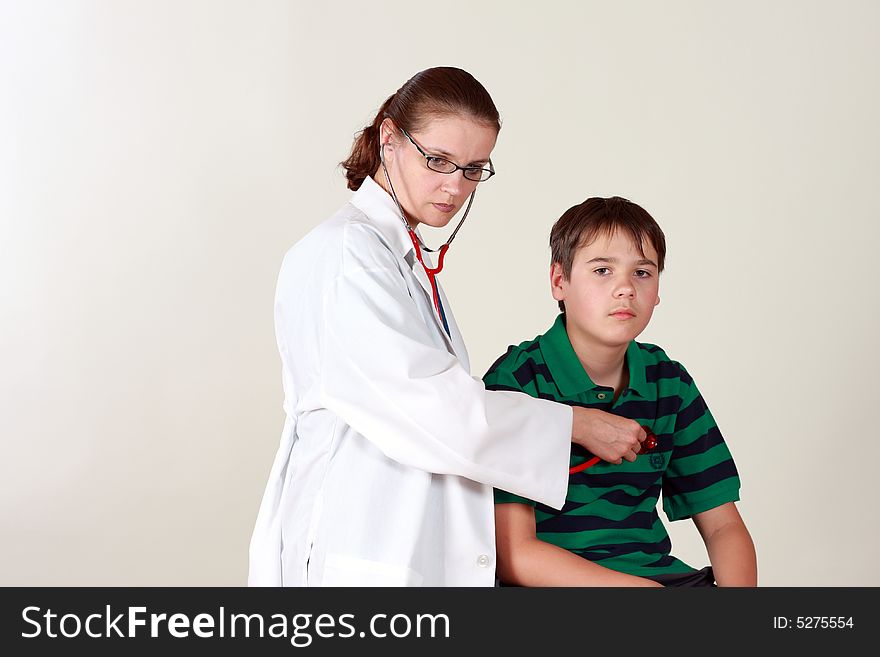 A female doctor examines a child patient using a stethoscope. A female doctor examines a child patient using a stethoscope