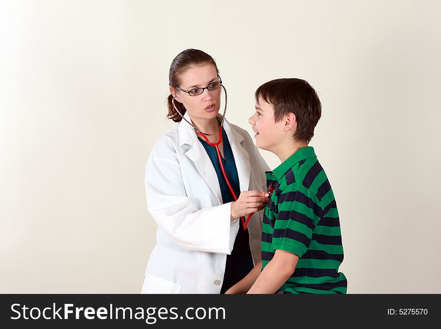 A female doctor examines a child patient using a stethoscope. A female doctor examines a child patient using a stethoscope