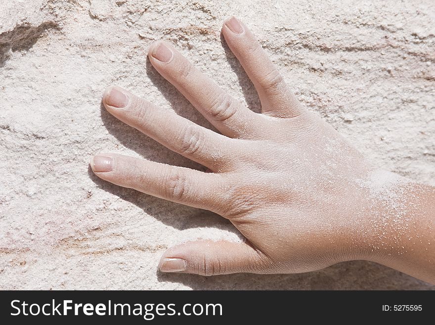 Hand on pink sand wall