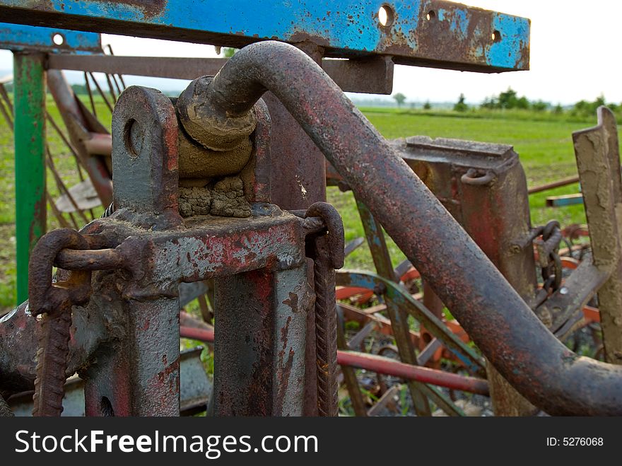 Detail of a farm machine in front of a grain field