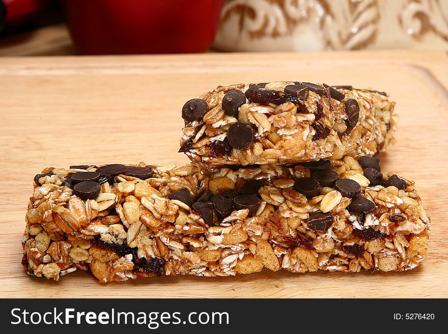 Two organic oat honey and chocolate chip snack bars in kitchen. Two organic oat honey and chocolate chip snack bars in kitchen.