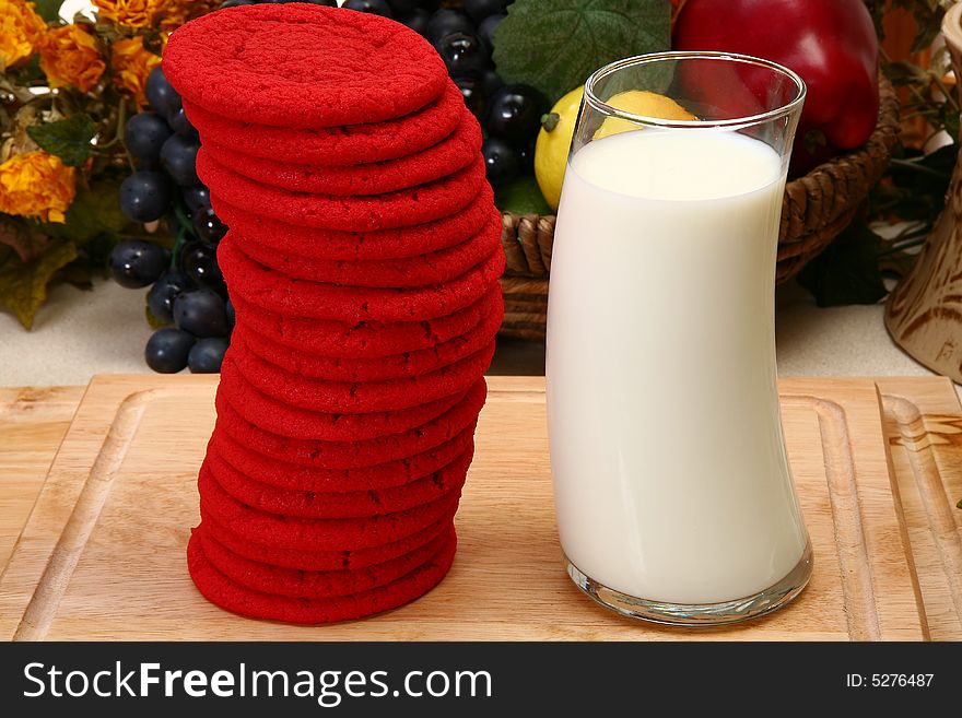 Stack of red sugar cookies and glass of milk in kitchen. Stack of red sugar cookies and glass of milk in kitchen.