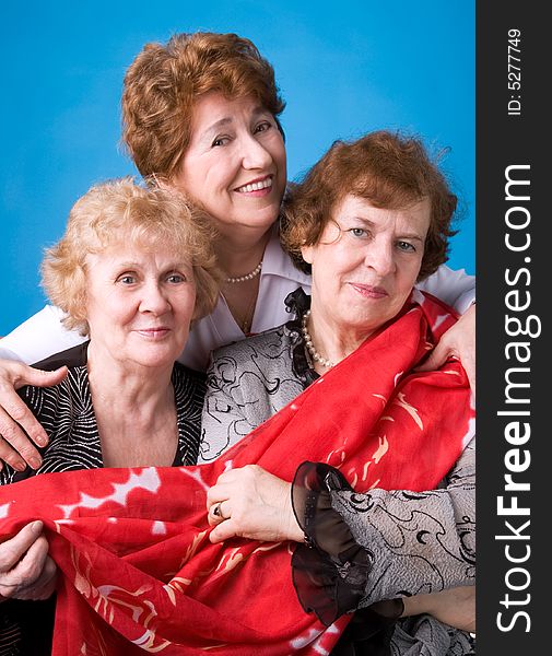 A portrait of three cheerful elderly women on a dark blue background. A portrait of three cheerful elderly women on a dark blue background.