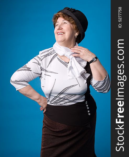 The cheerful elderly woman in a white dress on a blue background. The cheerful elderly woman in a white dress on a blue background.