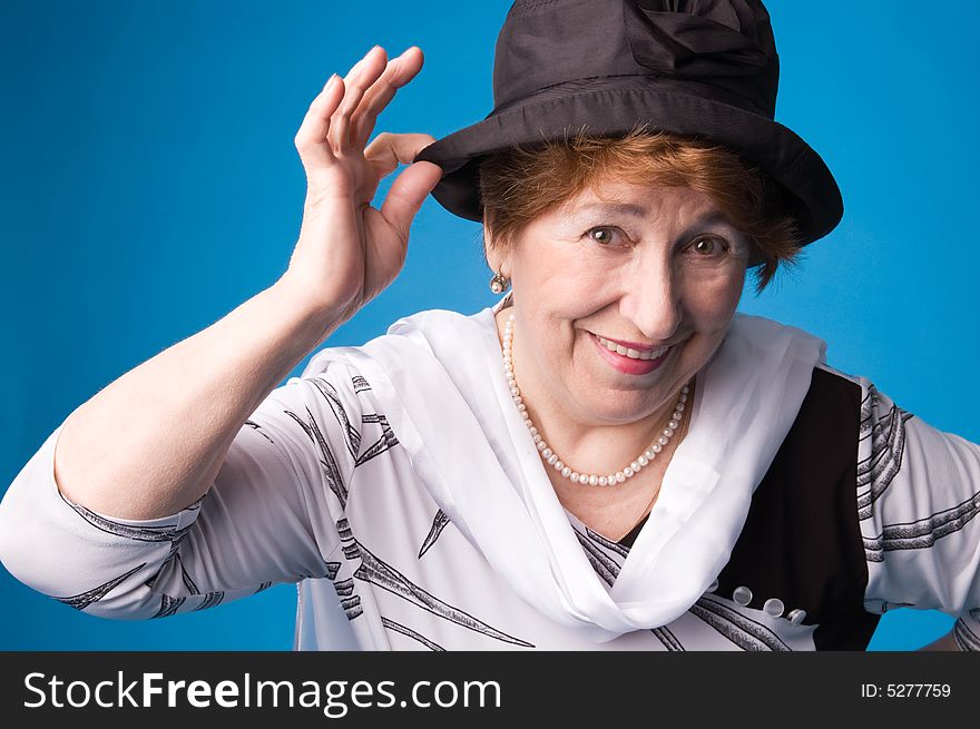 The cheerful elderly woman in a white dress on a blue background. The cheerful elderly woman in a white dress on a blue background.