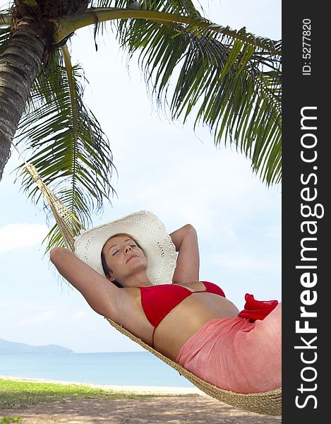View of nice woman lounging in hammock in tropical environment. View of nice woman lounging in hammock in tropical environment