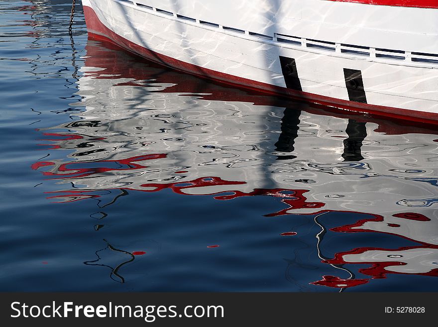 Reflections of a wooden boat in the harbour water. Reflections of a wooden boat in the harbour water