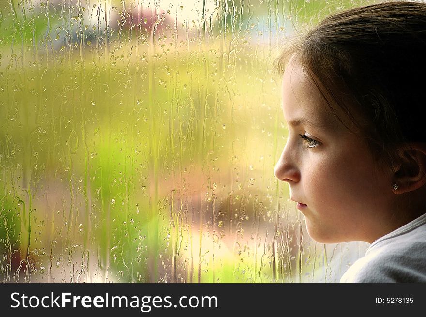 Girl looking out window on a rainy day. Girl looking out window on a rainy day