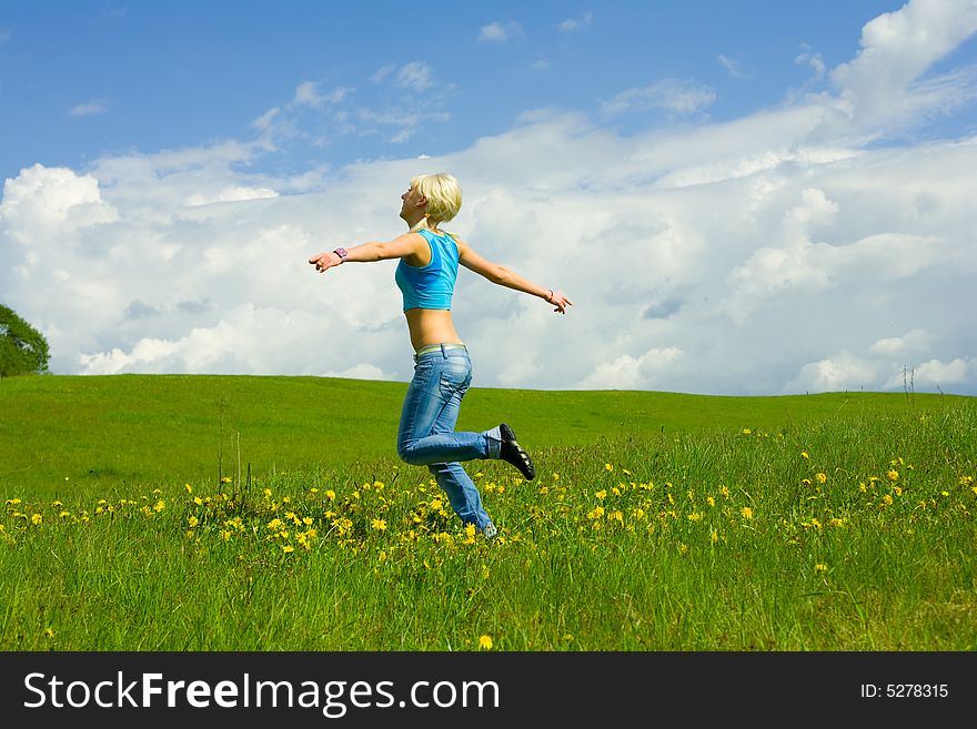The girl jumping on a lawn