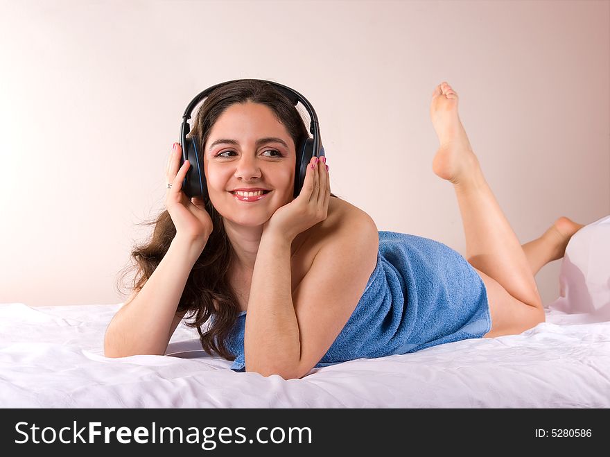 Girl Smiling in a blue towel with headphones