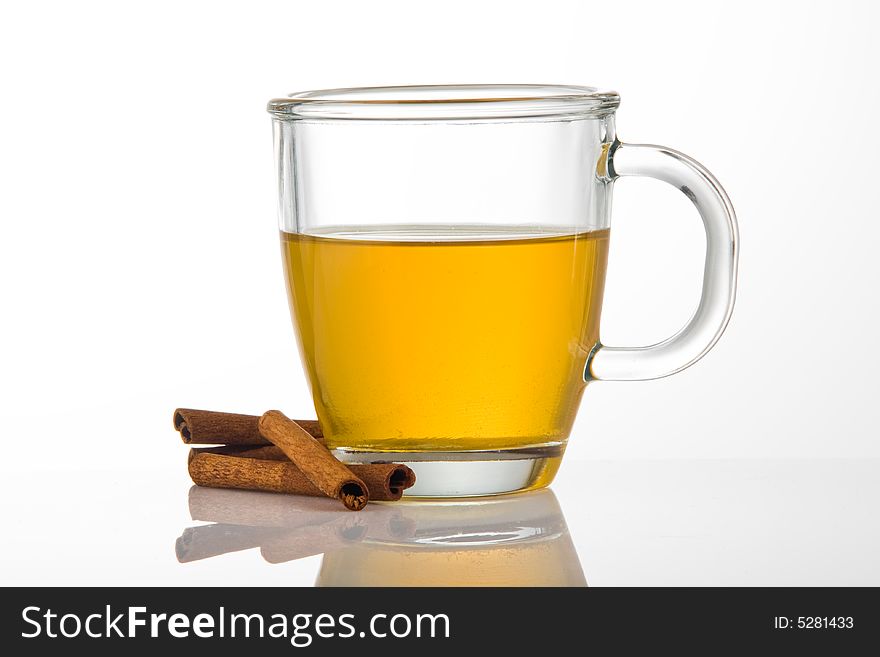 Cup of tea on white reflective surface with cinnamon sticks. Cup of tea on white reflective surface with cinnamon sticks