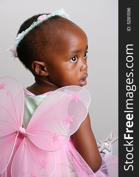 Toddler girl in a pink fairy costume with wings and head piece