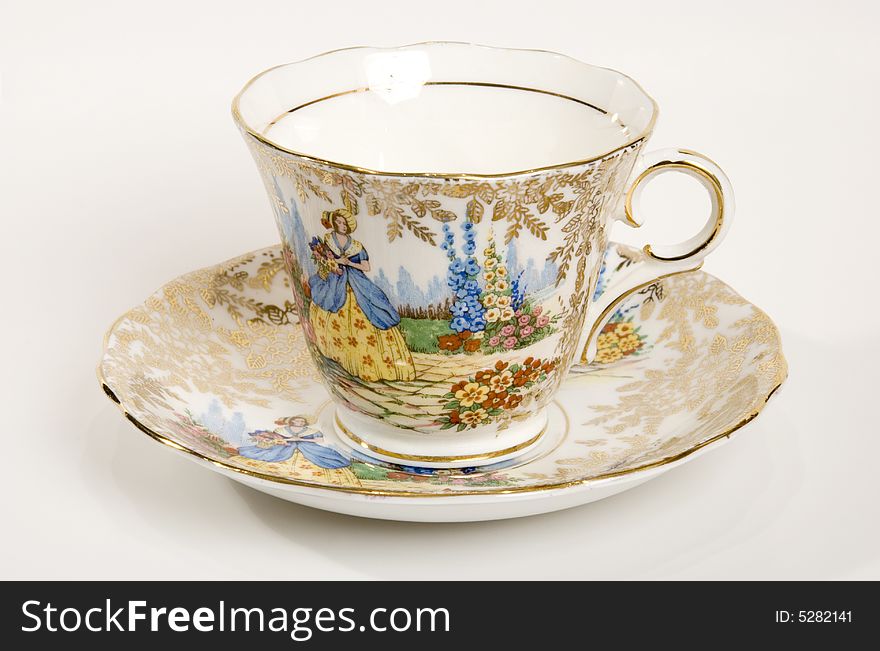 An antique tea cup with gold detail and floral pattern