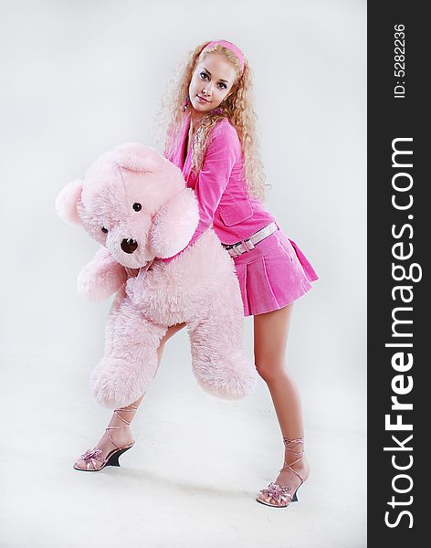 The girl dressed in pink with a teddy-bear in hands. The girl dressed in pink with a teddy-bear in hands