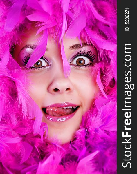 The face of girl is surrounded pink feathers. The face of girl is surrounded pink feathers