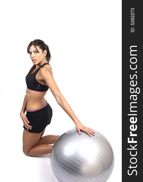 Beautiful brunette woman exercising with a gray yoga ball