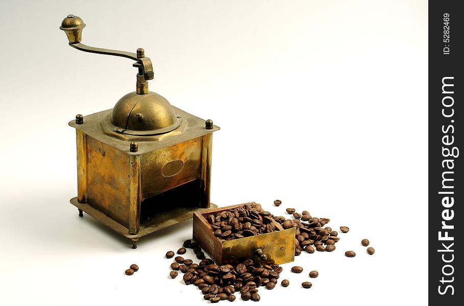 Antiquity coffee machine with beans over white