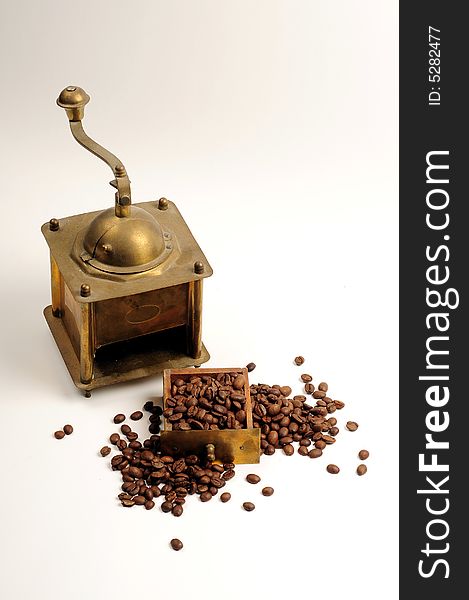 Antiquity coffee machine with beans over white