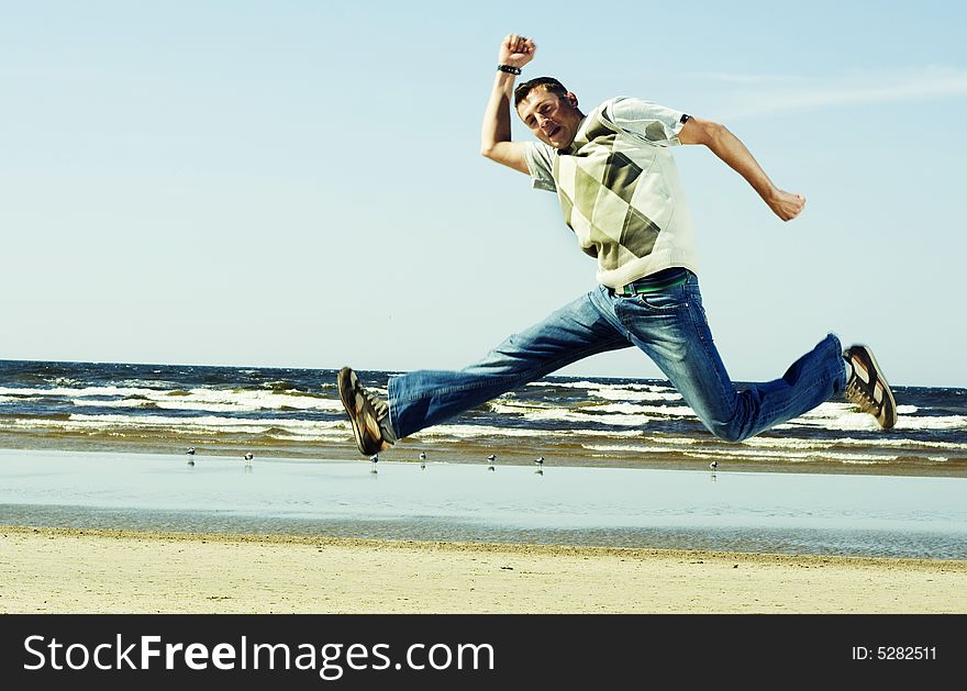Young happy men jumping on the beach. Young happy men jumping on the beach.