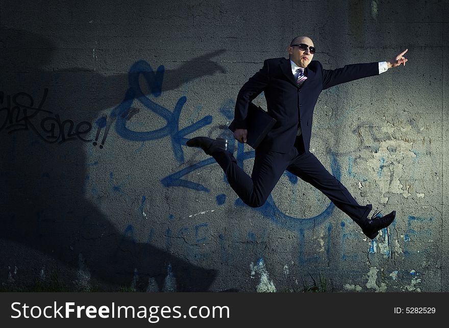 Jumping businessman with case showing direction. Jumping businessman with case showing direction.