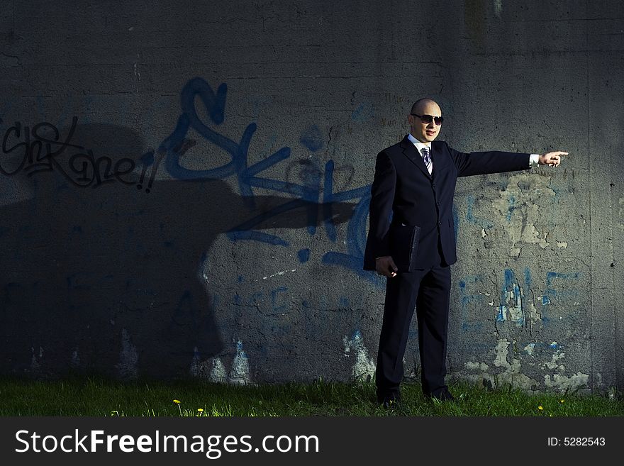 Businessman in black suit showing direction. Businessman in black suit showing direction.