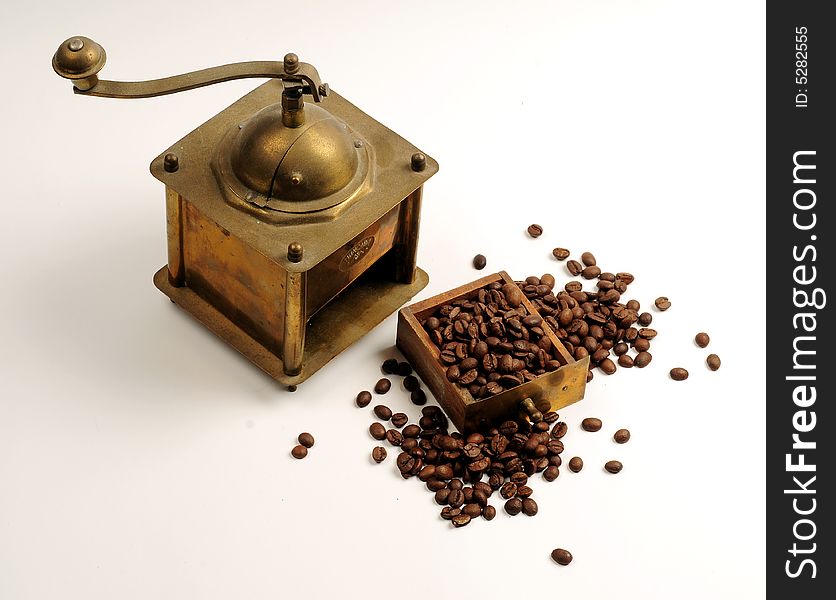 Antiquity coffee machine with beans over white