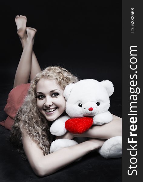 The girl laying embraces the teddy-bear. The girl laying embraces the teddy-bear