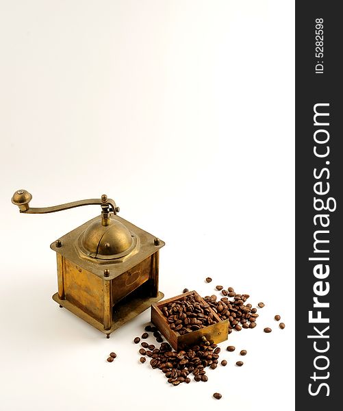 Antiquity coffee machine with beans over white