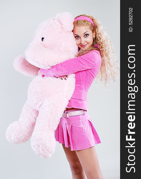 The girl dressed in pink with a teddy-bear in hands. The girl dressed in pink with a teddy-bear in hands