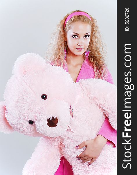 The girl dressed in pink with a teddy-bear in hands. The girl dressed in pink with a teddy-bear in hands