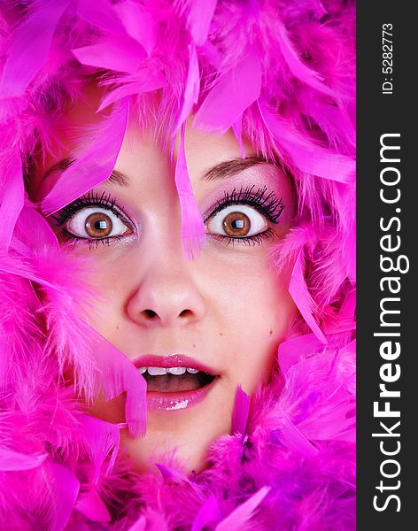 The face of girl is surrounded pink feathers. The face of girl is surrounded pink feathers