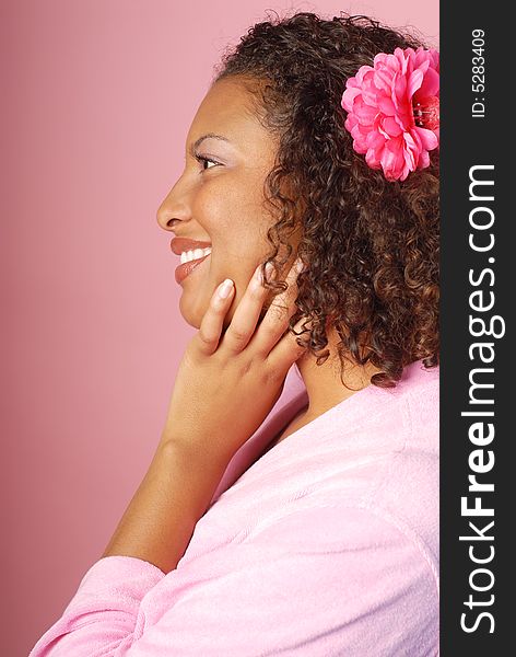 Profile view of a woman in a bathrobe at a spa on pink background. Profile view of a woman in a bathrobe at a spa on pink background