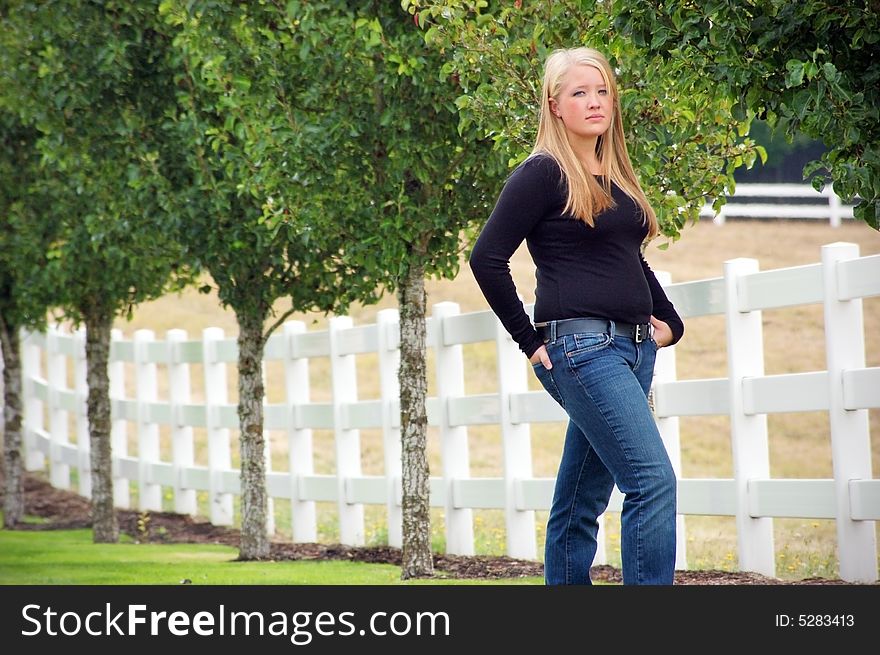 Teen Girl Standing Next to a Fence