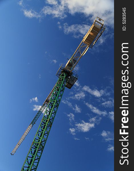 Construction crane against cloudy blue sky