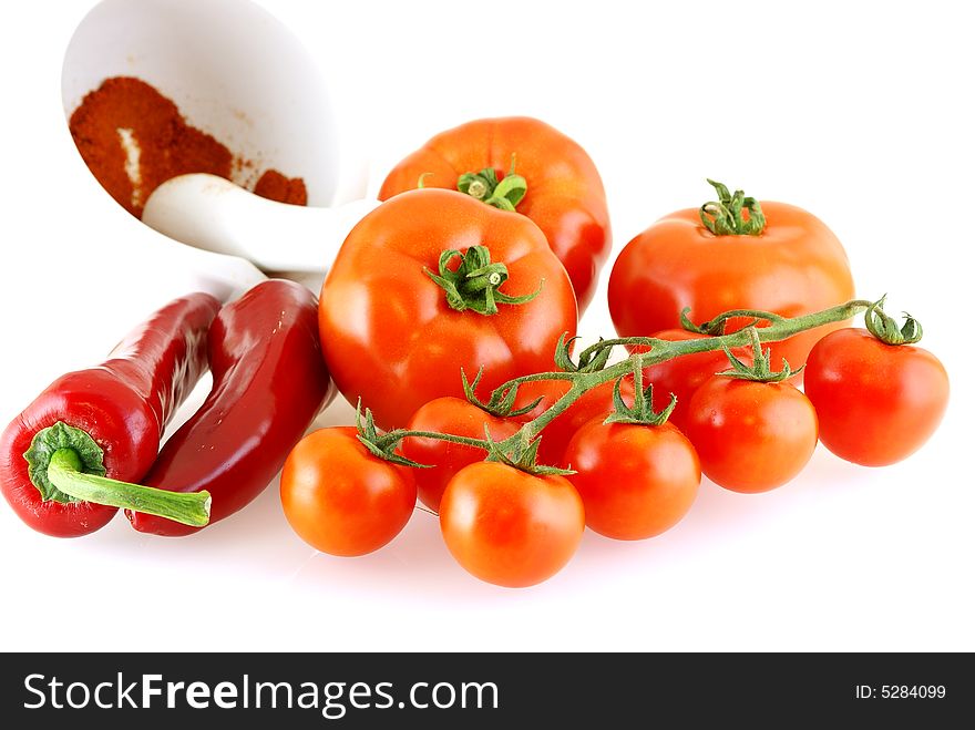 Lots of different tomatoes and red paprika over white background