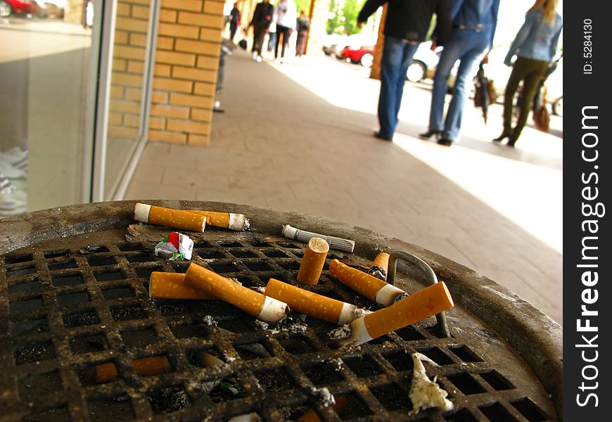 Stubs of cigarettes in  urn for dust in  public place