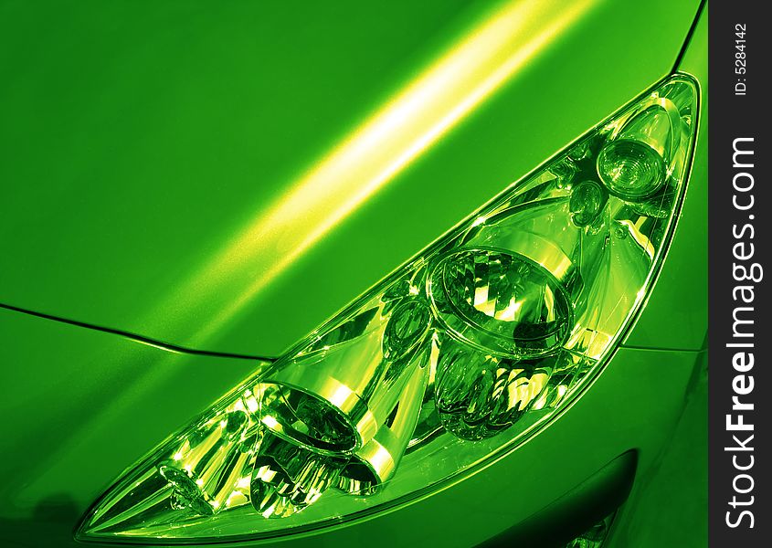 Headlight and cowl of  new automobile in green tonality