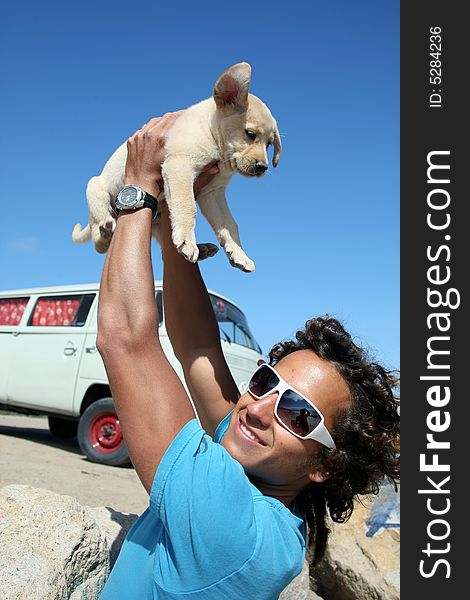 Young man holding his labrador puppy. Young man holding his labrador puppy